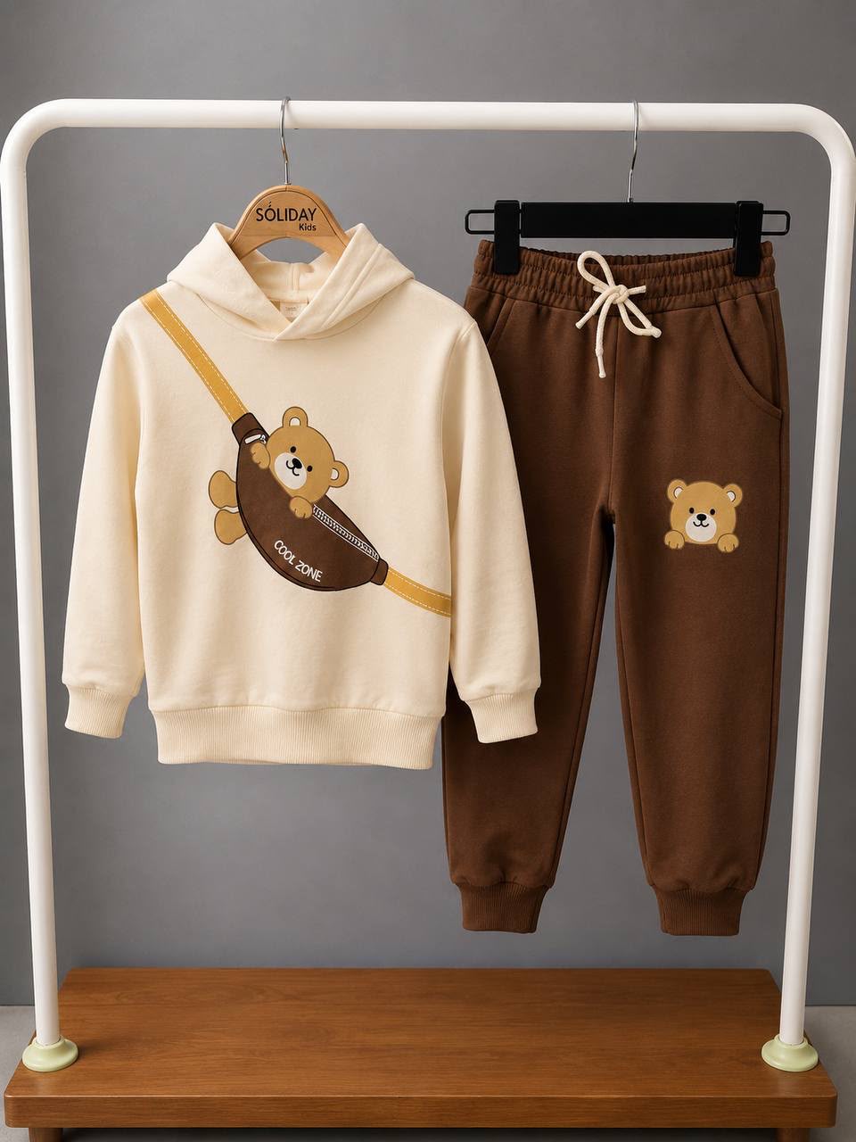 Jungen-Set Teddy Cool Zone am Bügel – cremefarbener Hoodie mit Bären-Print und brauner Jogginghose mit Bären-Patch