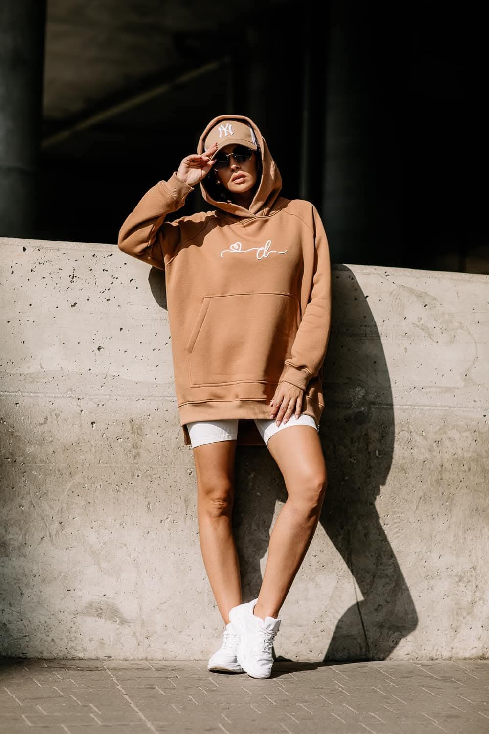 COTTONLAND Oversize-Hoodie in Toffee am Model, kombiniert mit weißen Radlershorts und Sneakers