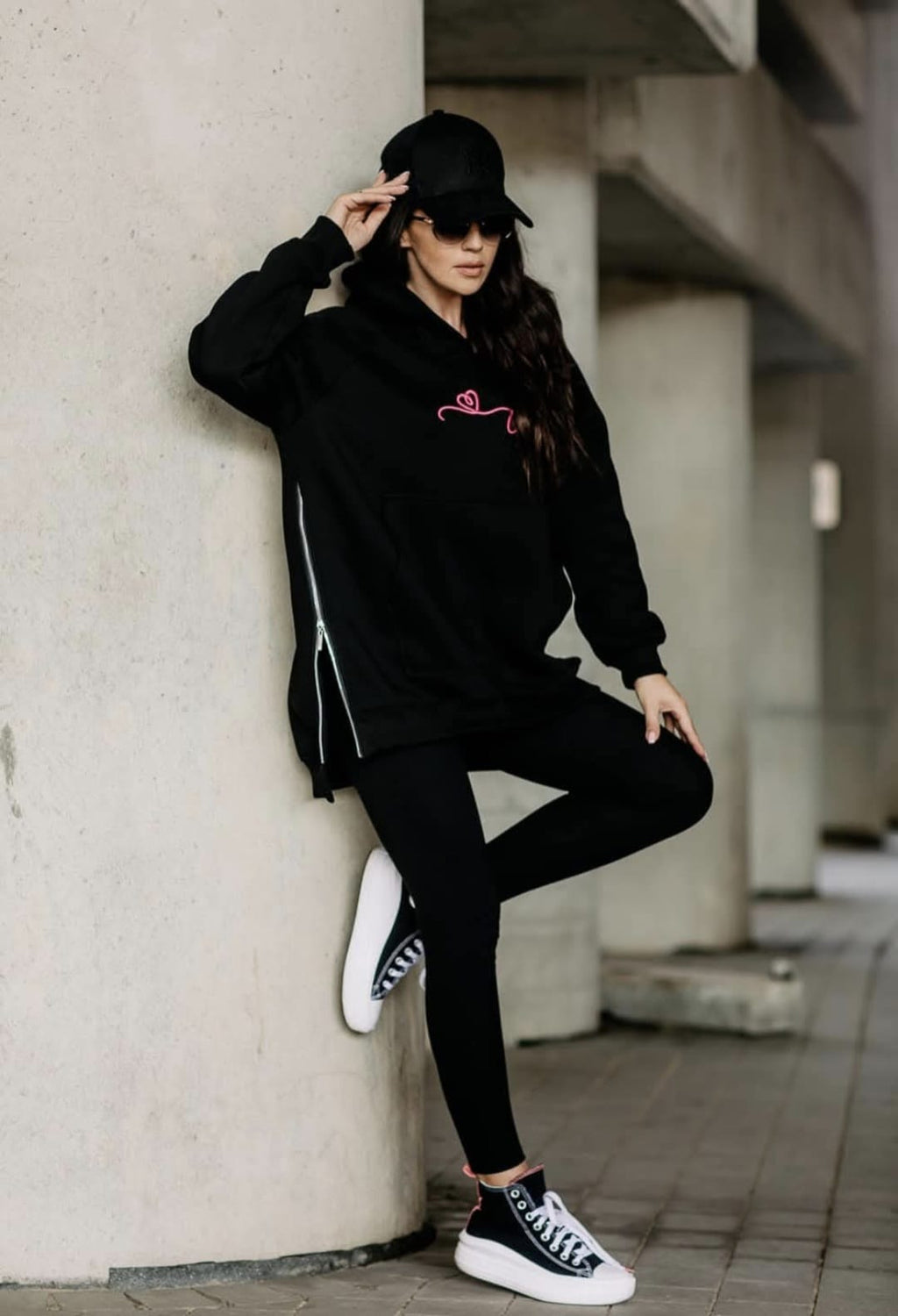Schwarzer COTTONLAND Hoodie mit geöffnetem seitlichem Reißverschluss, kombiniert mit Leggings und hohen Sneakers