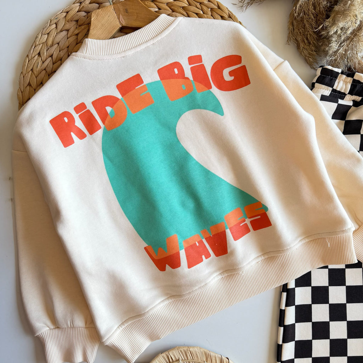 Oversize-Sweater von hinten mit großem „Ride Big Waves“-Print in Orange und türkiser Welle