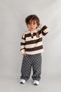 Kleinkind im Teddy-Check-Kinder-Set mit gestreiftem Oberteil mit Teddy-Patch und grauer Karohose, Studioshotaufnahme