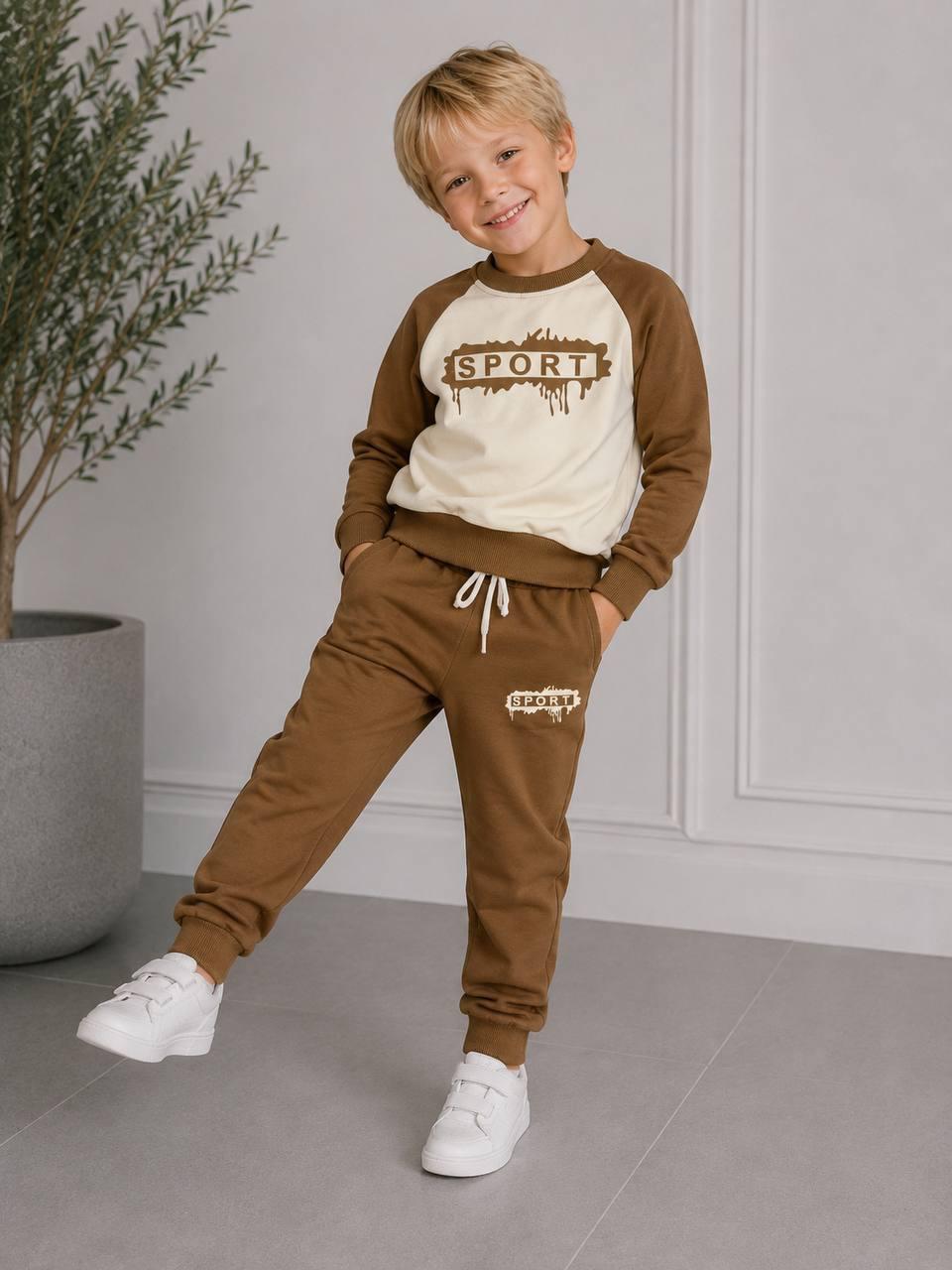 Junge trägt ein braun-cremefarbenes Happy Street Sweatset mit SPORT-Print, Raglanärmeln und Jogginghose mit Kordelzug.