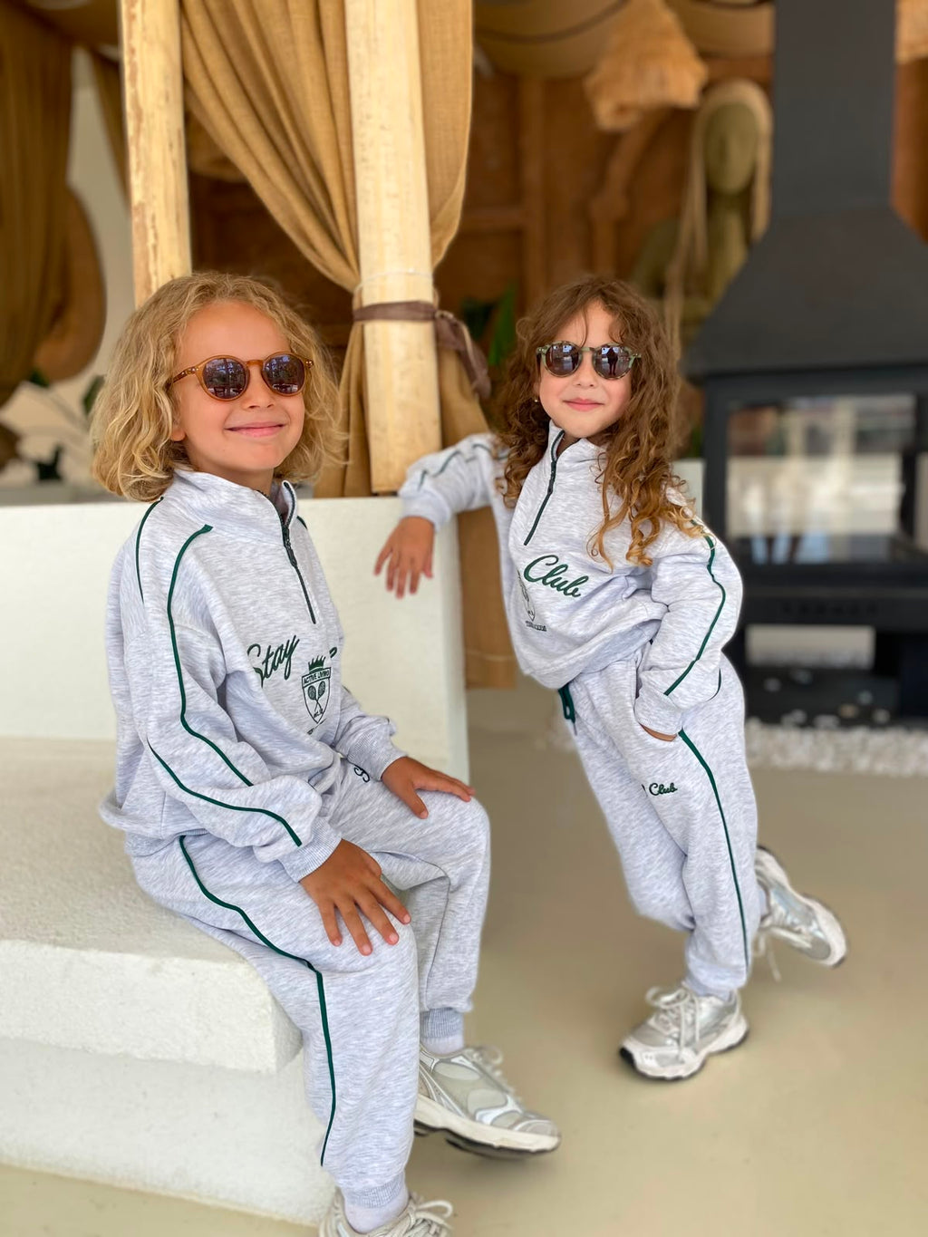Stay Club Kids Set: hellgraues 2-teiliges Set mit dunkelgrünen Paspeln, von zwei Kindern mit Sneakern