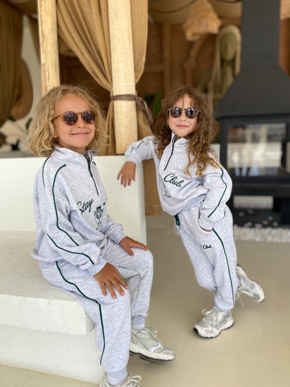 Stay Club Kids Set: hellgraues 2-teiliges Set mit dunkelgrünen Paspeln, von zwei Kindern mit Sneakern