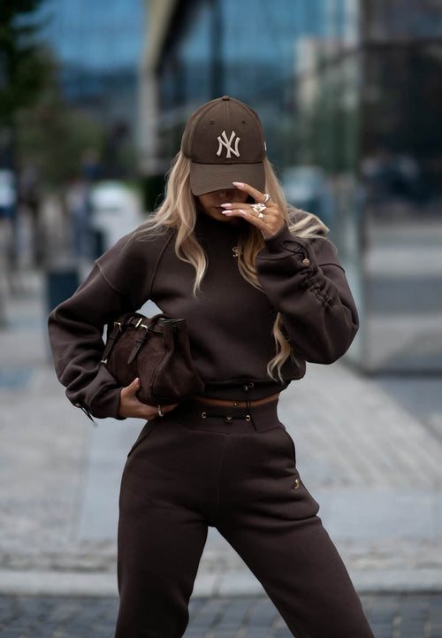 Damen Sweat Set in Braun: kurzer Sweater mit Tunnelzug und Slim Fit Hose, kombiniert mit Cap und Tasche