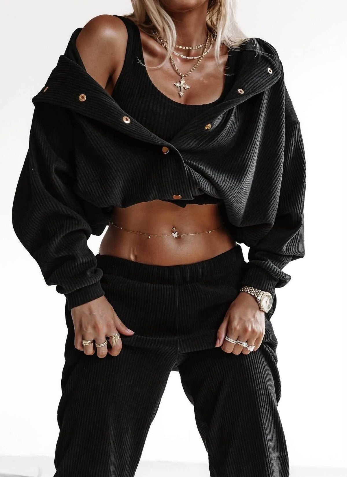 Schwarzes 3-teiliges Ripp-Set: Jacke mit Druckknöpfen offen über die Schulter gelegt, Crop-Top und Hose