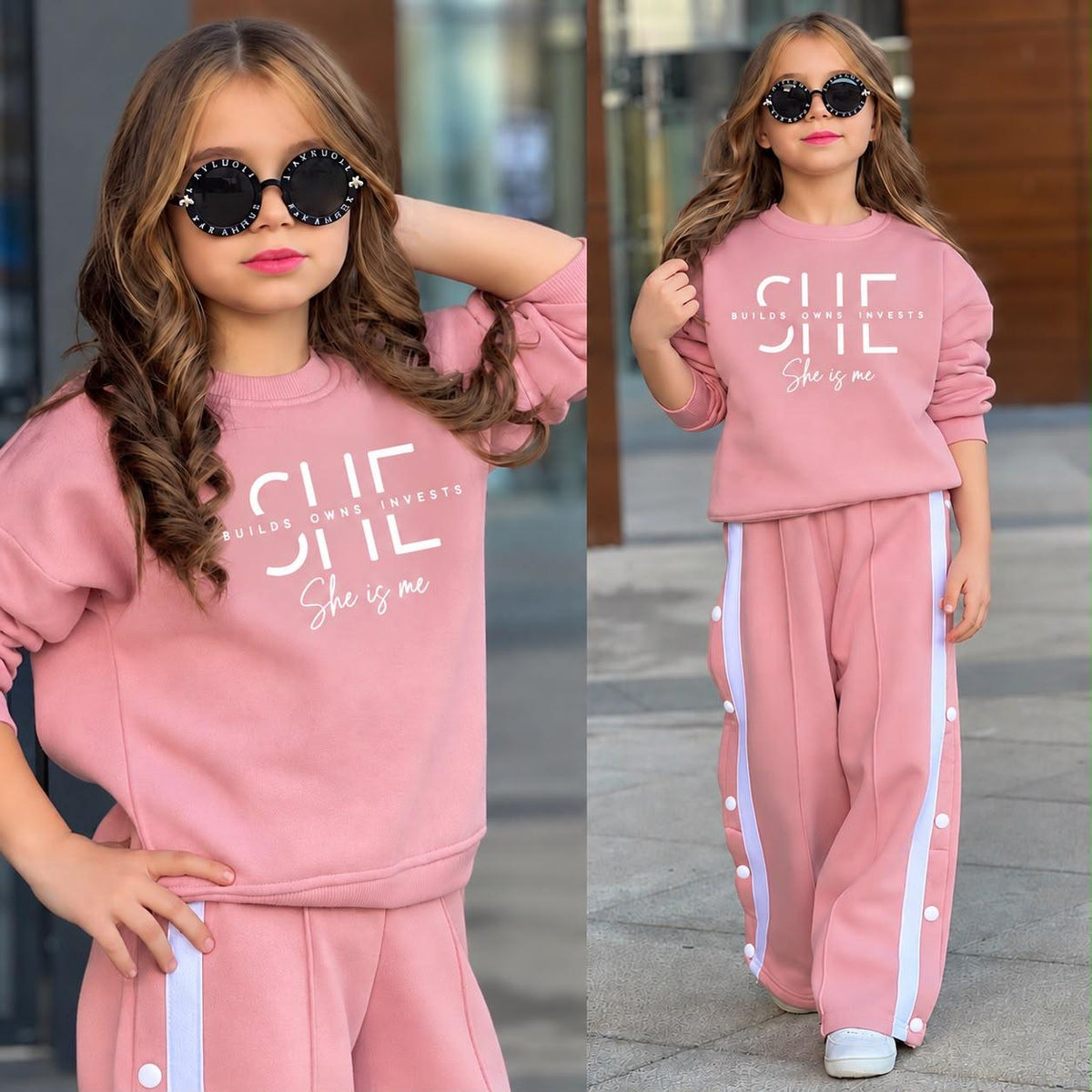  Mädchen im altrosa Sweatset „She Is Me“ mit weißem Schriftzug und weiter Hose mit weißen Seitenstreifen und Knöpfen.