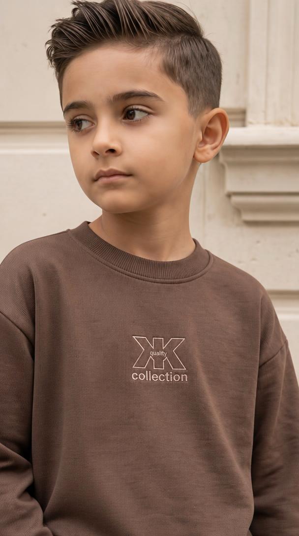 Nahaufnahme des schokobraunen X Collection Sweatshirts am Jungen mit Rundhalsausschnitt und dezentem Logo auf der Brust