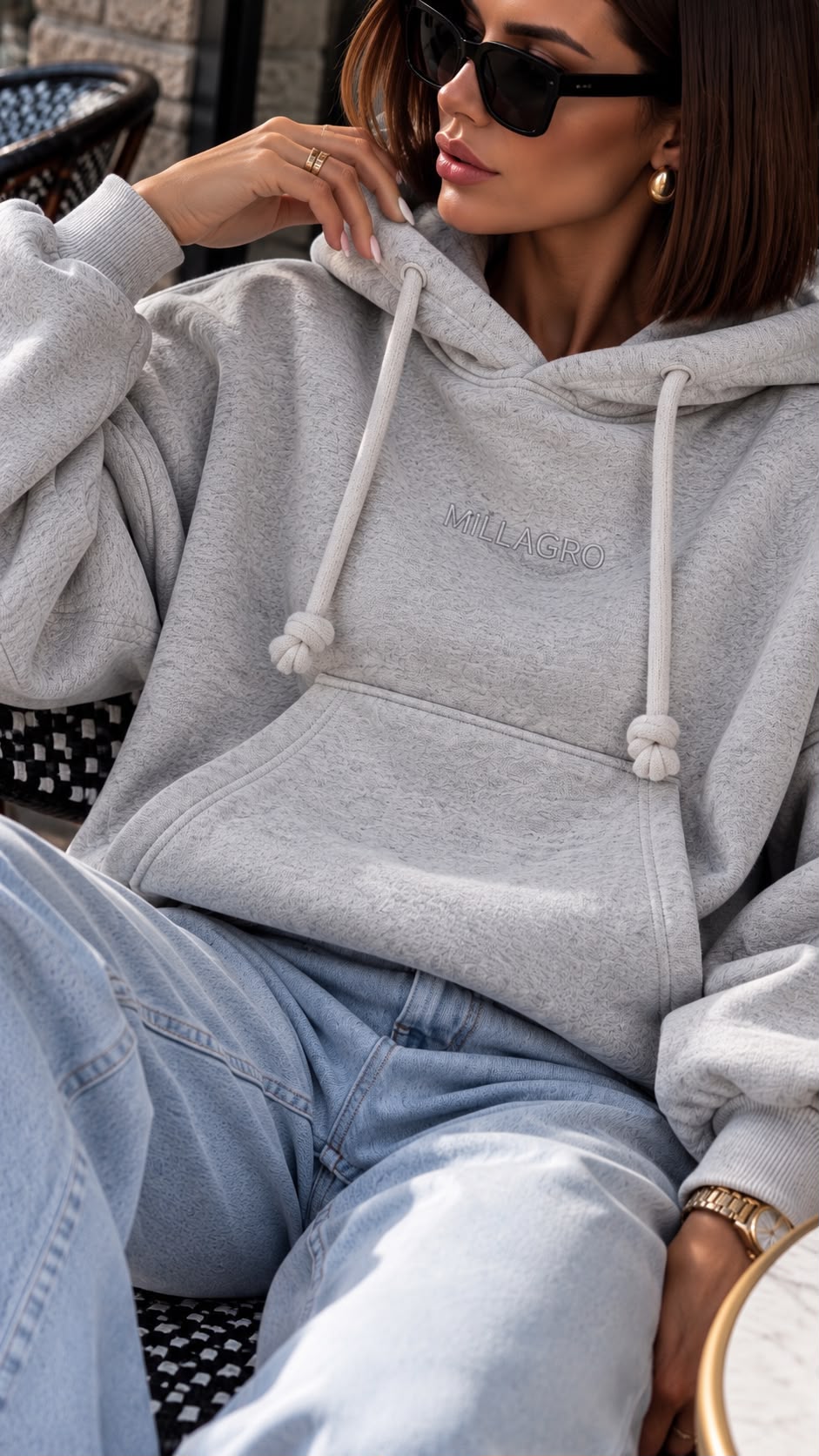 Nahaufnahme des MILLAGRO MONROU Hoodies in Hellgrau mit Brustlogo, Kapuzenkordeln und Kängurutasche.