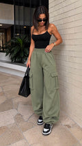 MILLAGRO Damen-Cargo-Jogger in Khaki mit seitlichen Pattentaschen und weitem Oversize-Schnitt, getragen mit schwarzem Top und Sneakers.