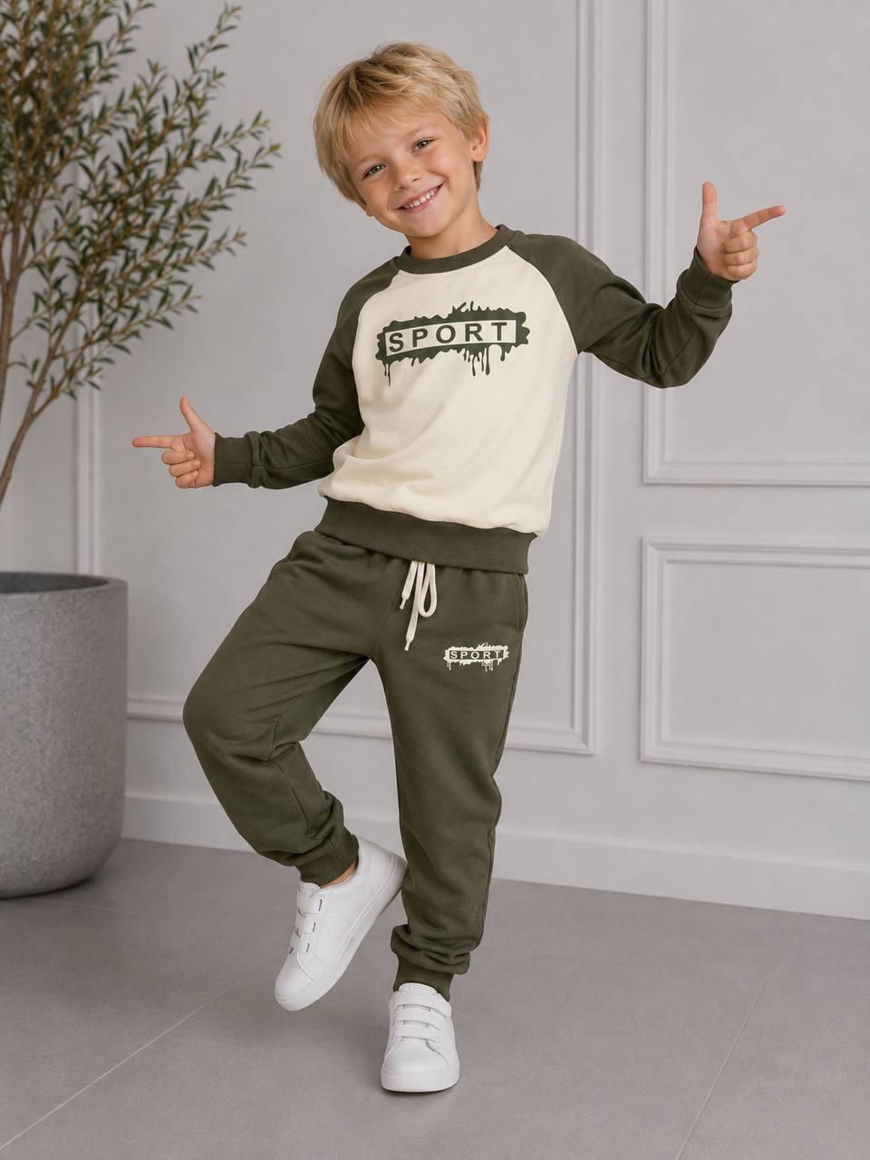 Junge zeigt das khaki-cremefarbene Happy Street Sweatset mit SPORT-Print, kontrastfarbenen Raglanärmeln und Jogginghose.