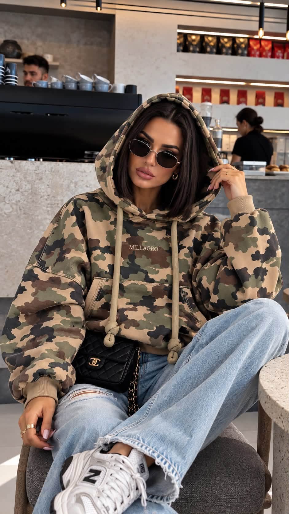 MILLAGRO MONROU Hoodie in Beige Camouflage mit Brustlogo, Kapuze und Kängurutasche, getragen mit Jeans.