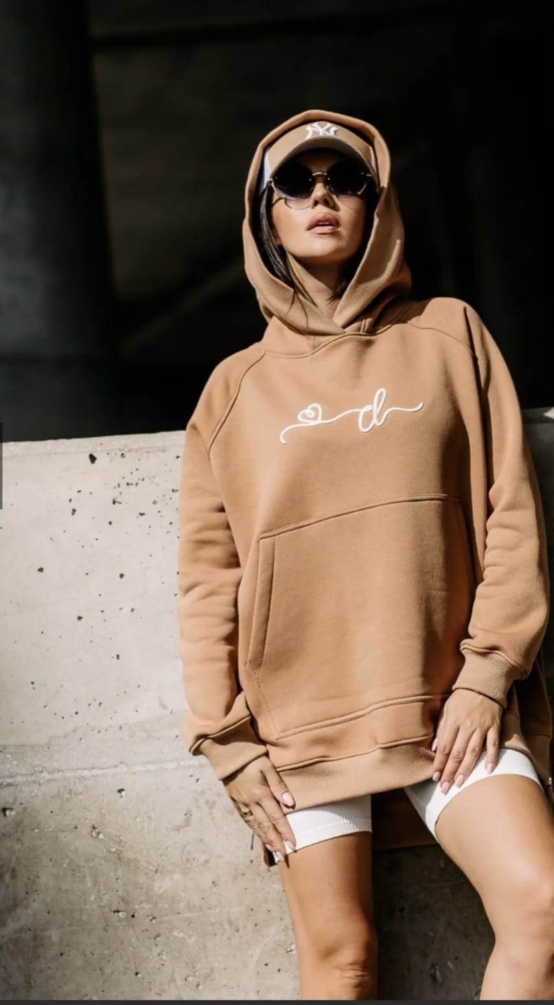 Vorderansicht des COTTONLAND Hoodies in Toffee mit großer Kapuze, Kängurutasche und heller Brustverzierung