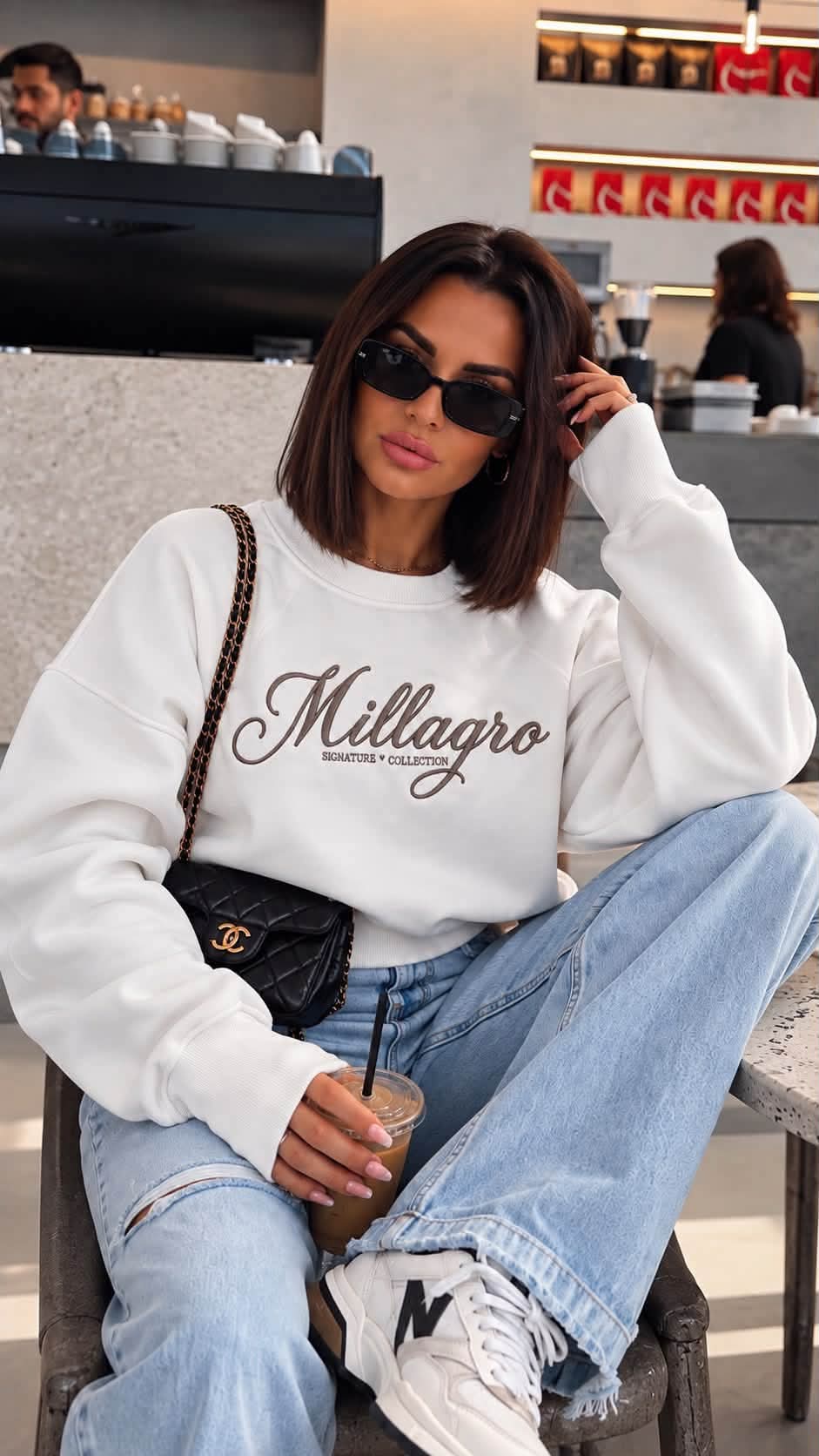 Weißes MILLAGRO Damen-Sweatshirt mit Signature-Collection-Stickerei und Rundhalsausschnitt, getragen mit hellblauer Jeans.